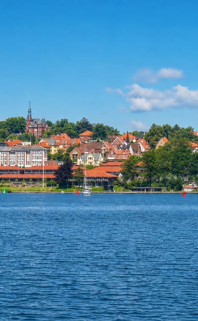 Svendborg seen across the sound, a wooded town with red roofs and sailboats, Denmark