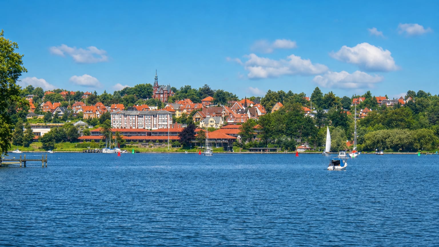 Svendborg seen across the sound, a wooded town with red roofs and sailboats, Denmark