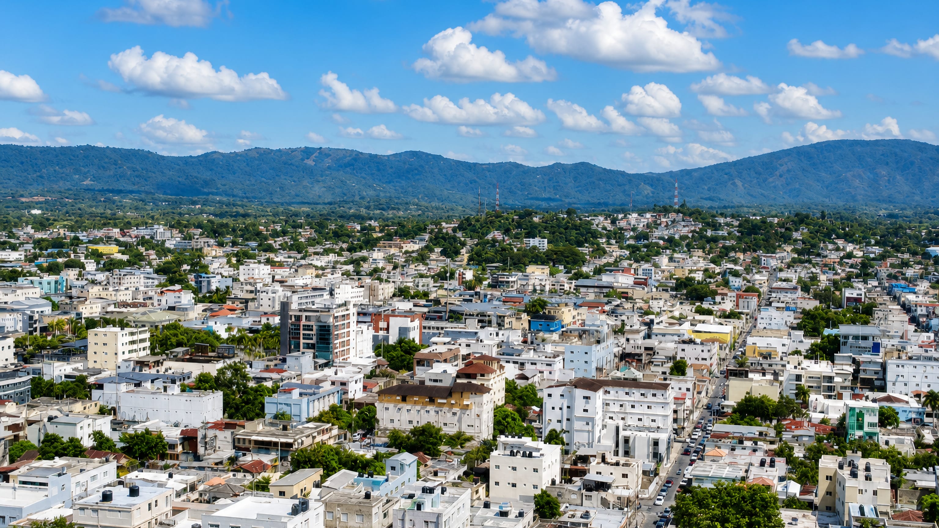 Aerial view of San Francisco de Macorís, Dominican Republic, with low-rise streets below forested mountains
