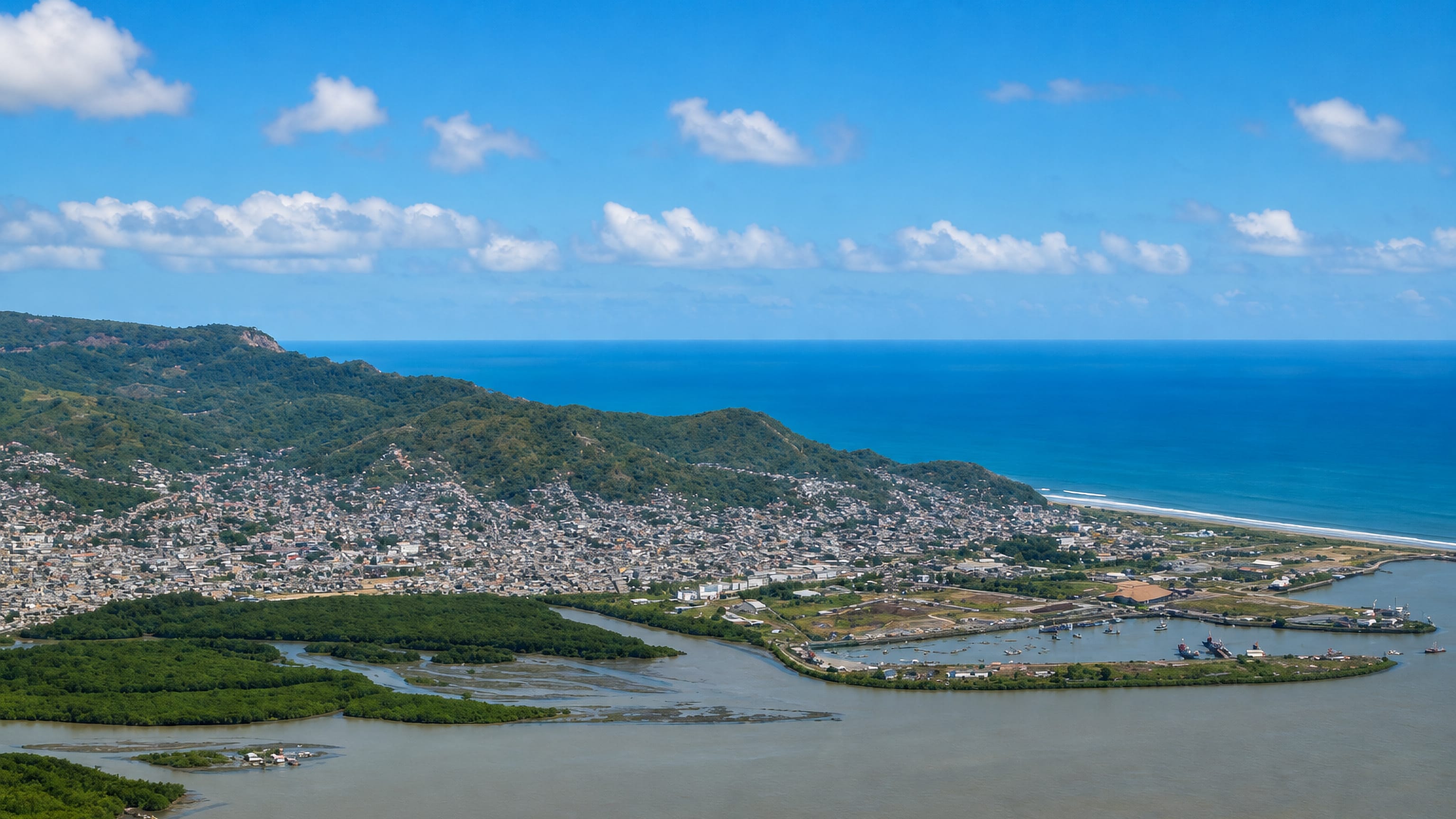 Aerial view of Esmeraldas, Ecuador, spread between green coastal hills, river mangroves and the Pacific.