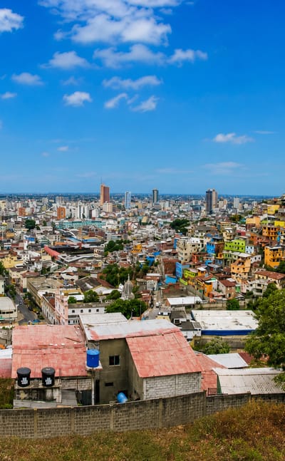 Guayaquil skyline along the Guayas River with downtown towers and the colorful stacked houses of Cerro Santa Ana