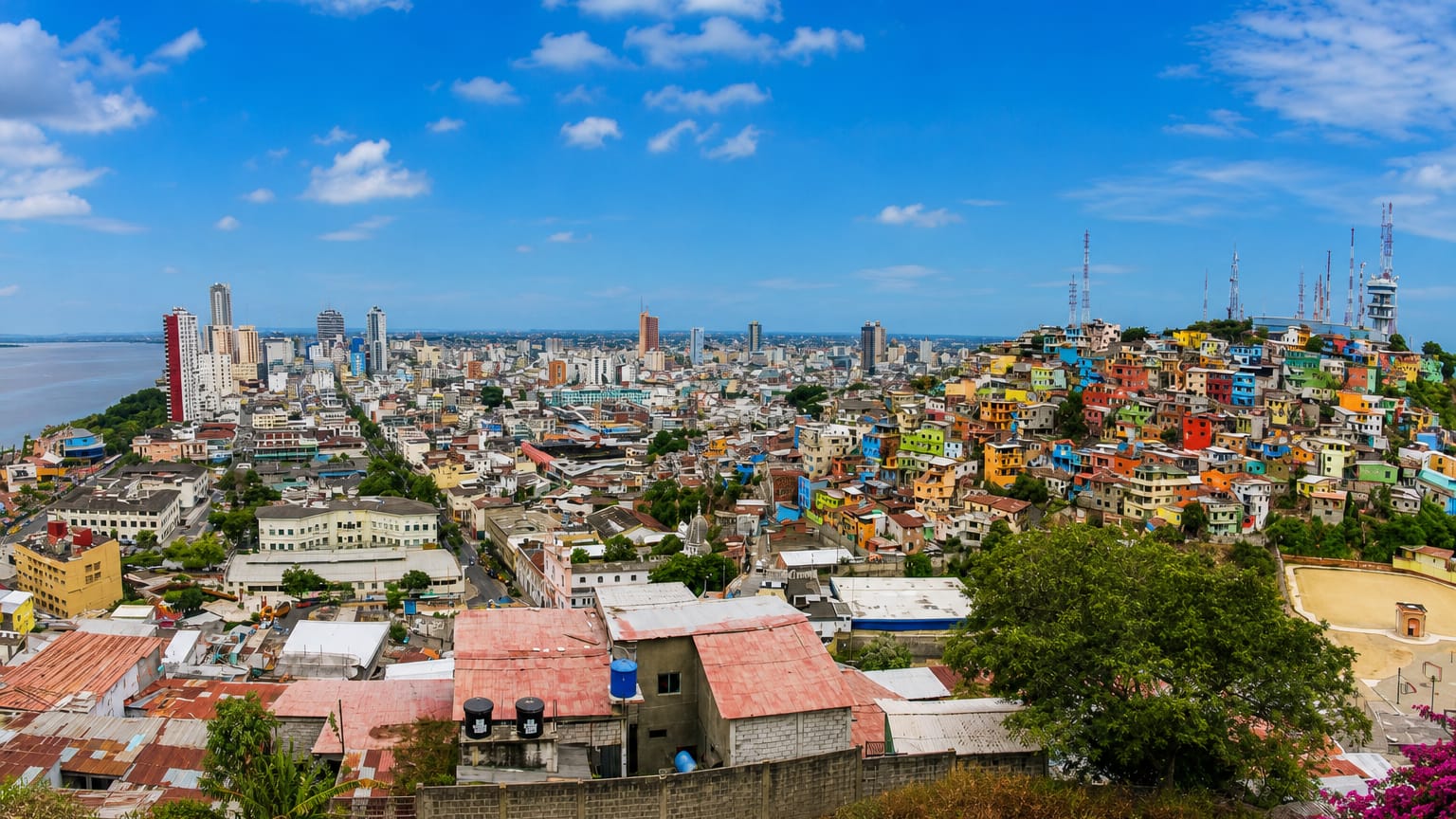 Guayaquil skyline along the Guayas River with downtown towers and the colorful stacked houses of Cerro Santa Ana