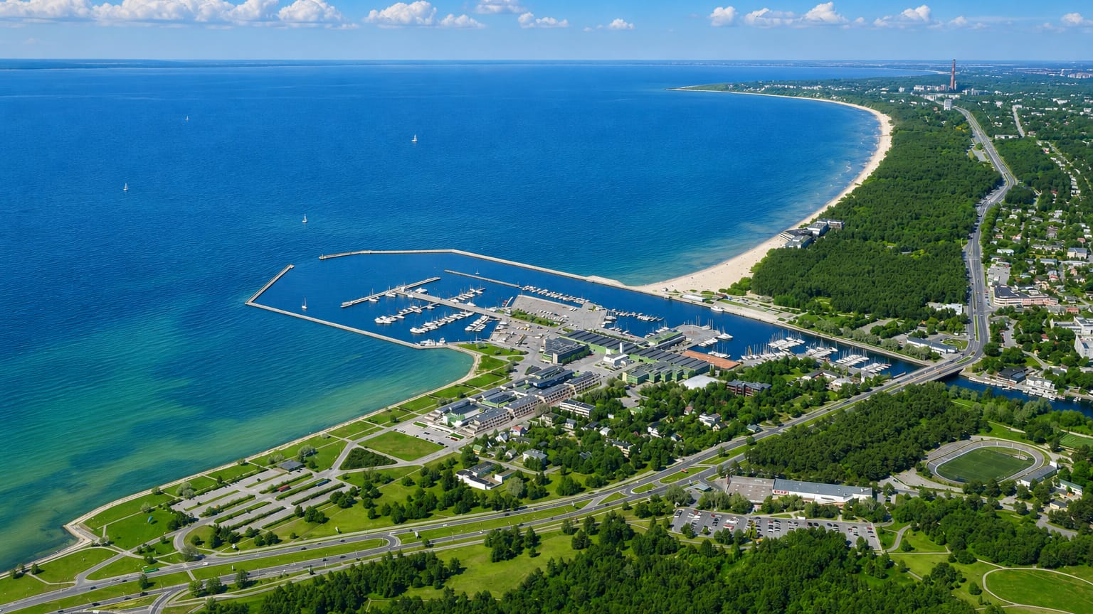 Aerial view of Pirita's yacht marina, sandy beach and pine-lined coastline on Tallinn Bay