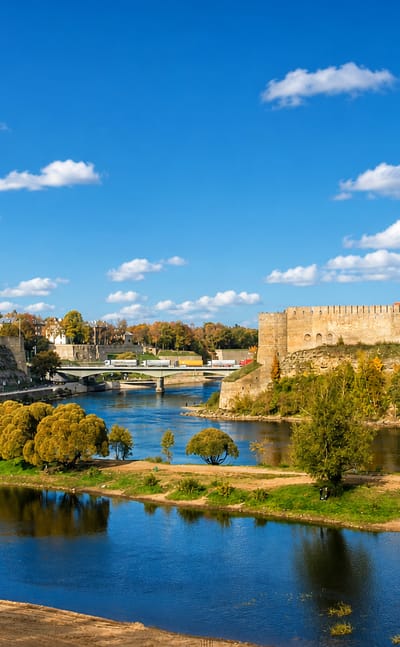 Narva's Hermann Castle facing the Ivangorod fortress across the river under a blue sky, Estonia