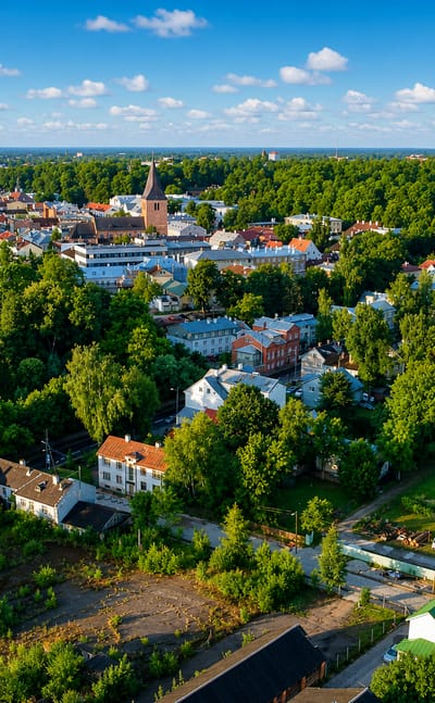 Aerial view of Tartu, Estonia, with St John's Church tower over the red-roofed old town and greenery.
