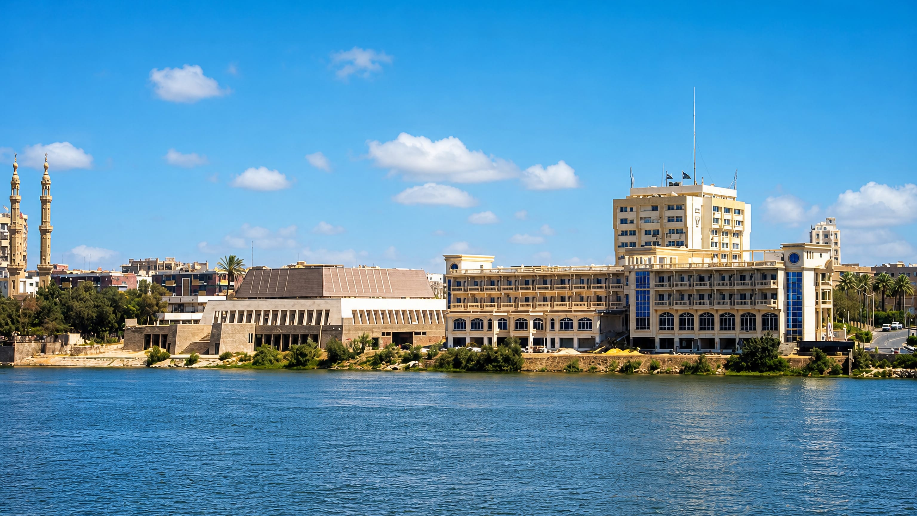 Nile waterfront at Sohag, Egypt, with a twin-minaret mosque and modern corniche buildings