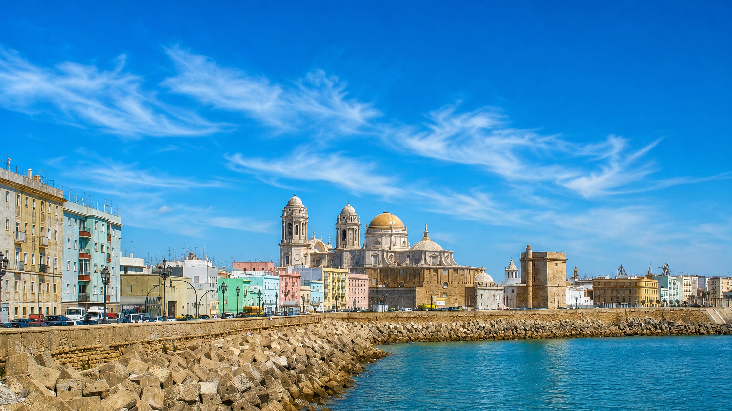 Cadiz seafront along Campo del Sur with the cathedral's golden dome and pastel houses above the Atlantic