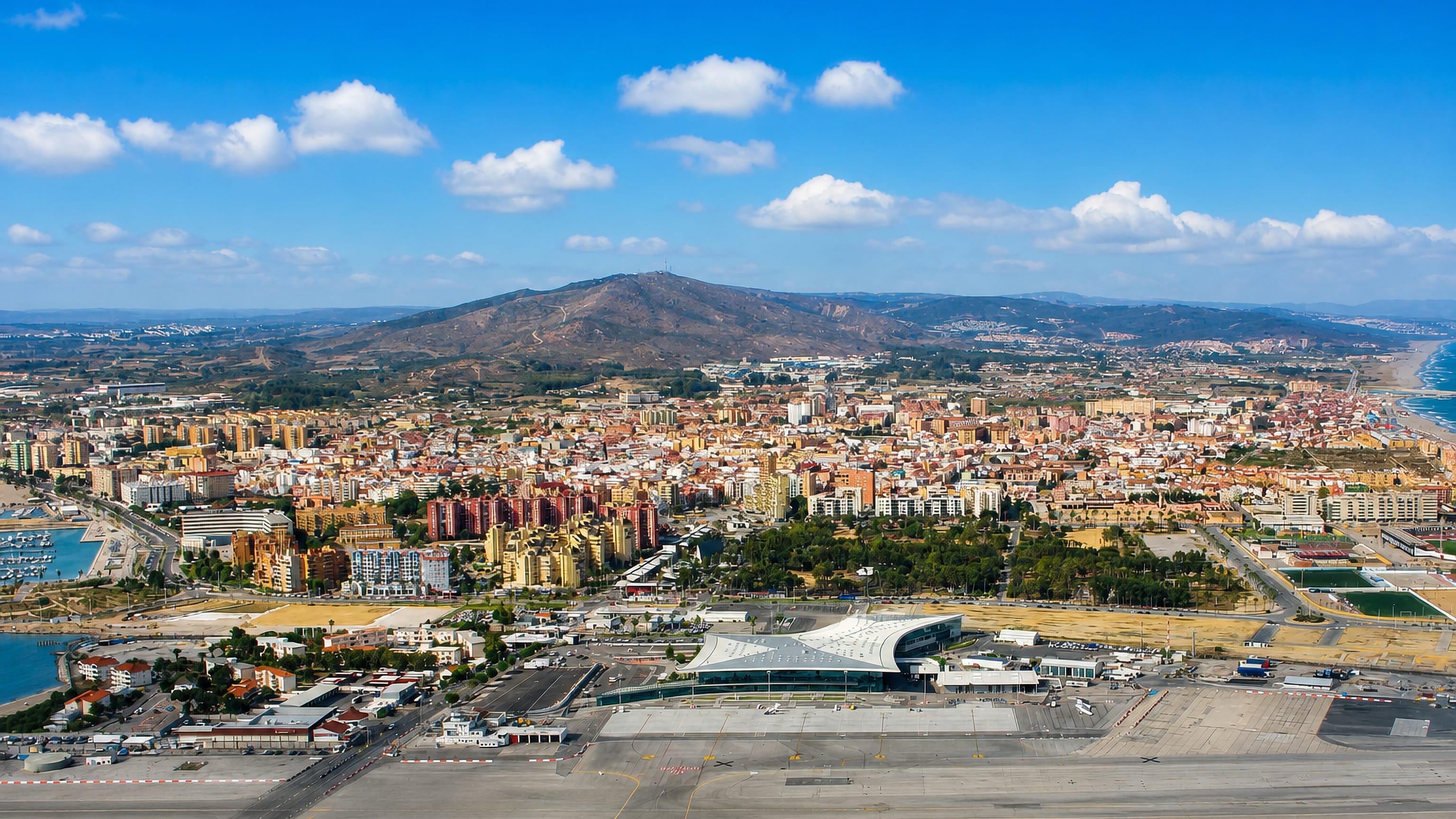 La Linea de la Concepcion, Spain, seen from Gibraltar across the airport runway, with beach, marina and hills.