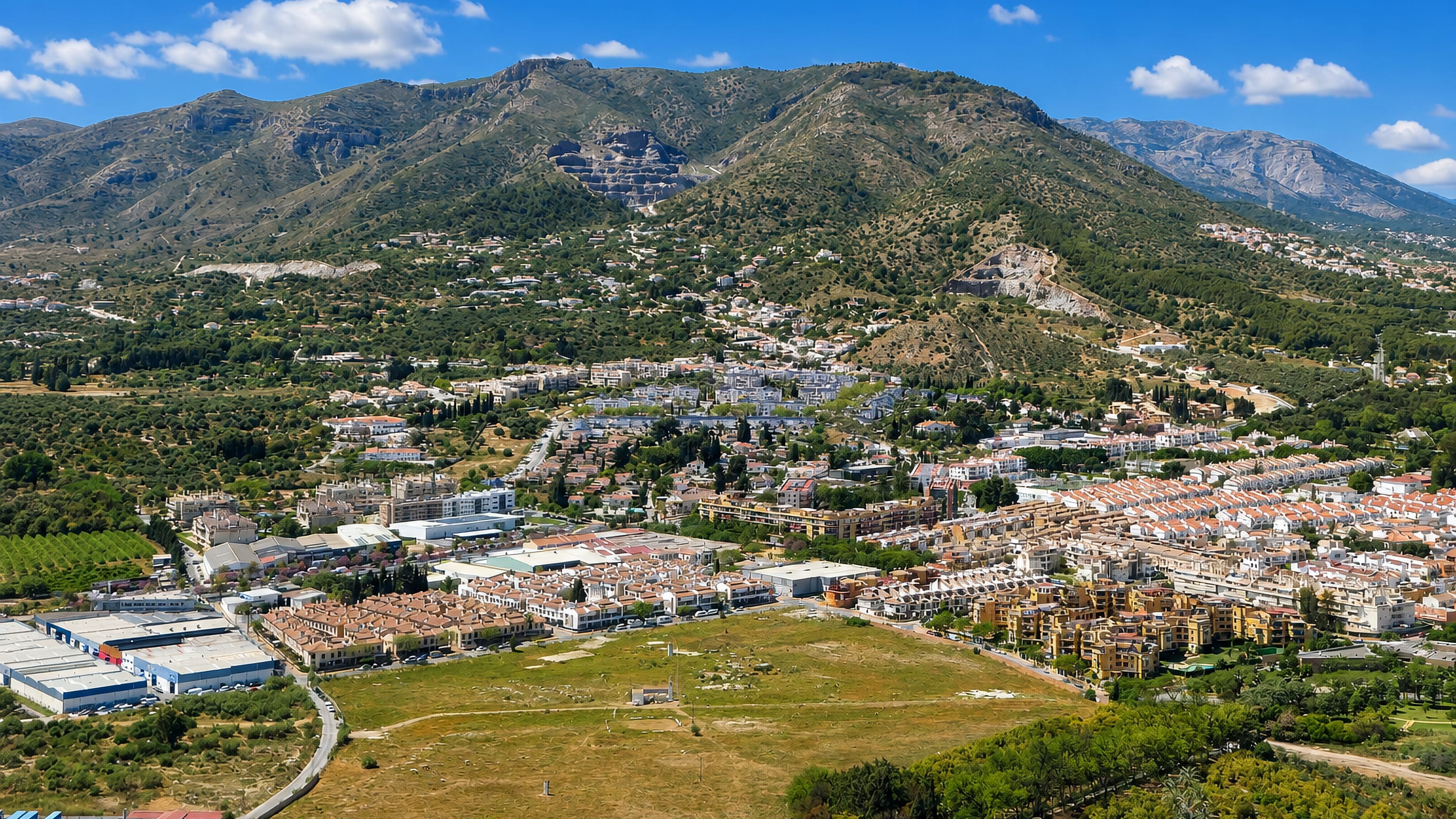Aerial view of Churriana, Málaga, with low-rise housing and industrial estates below the Sierra de Mijas.