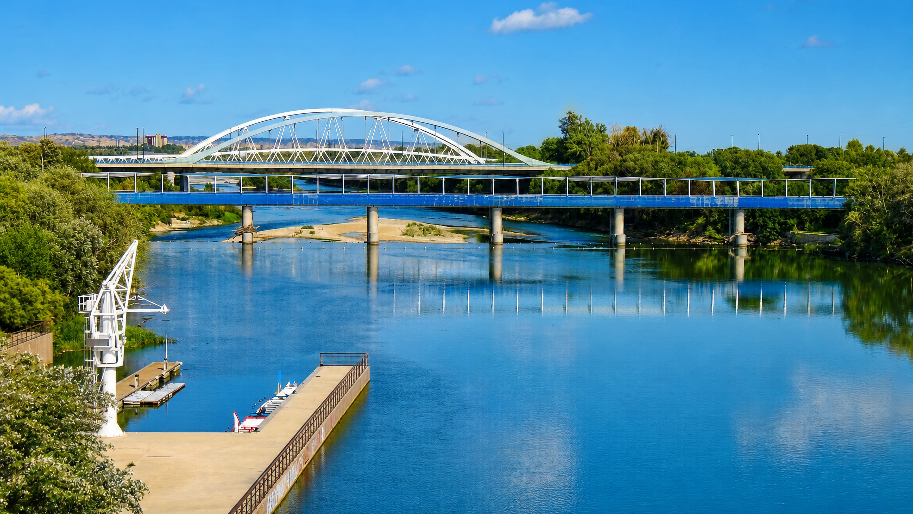 White arched bridge spanning the Ebro river beside the Las Fuentes district of Zaragoza.