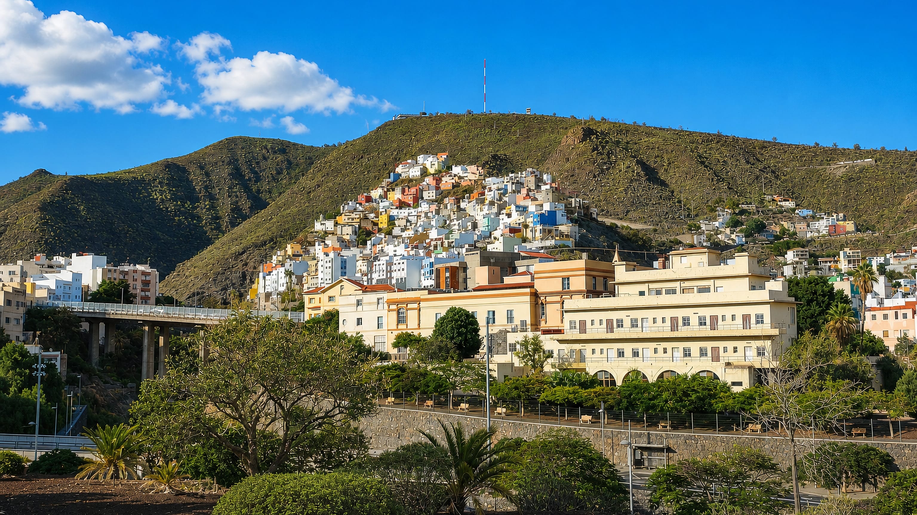 Colourful hillside houses above a large cream-walled building in Barrio Nuevo, Santa Cruz de Tenerife.