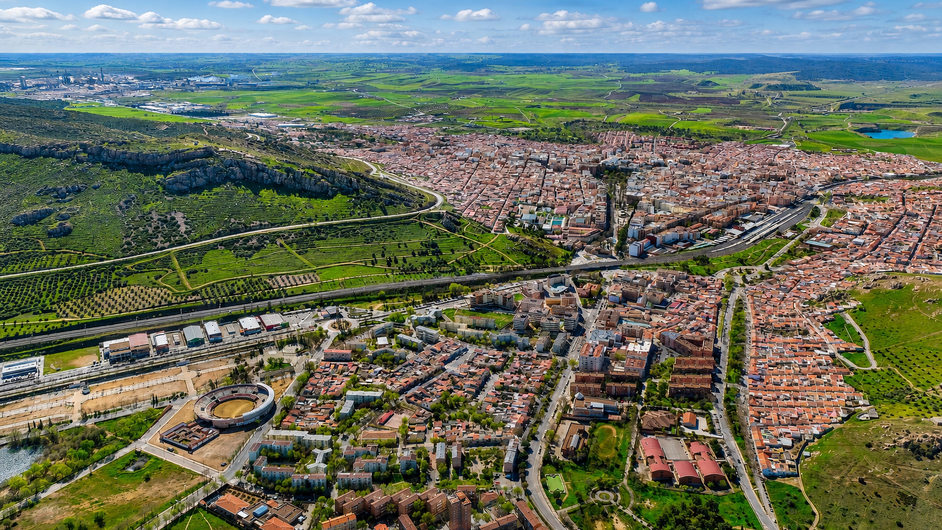 Aerial view of Puertollano, Spain, its bullring, dense town centre and the plains of Castilla-La Mancha.