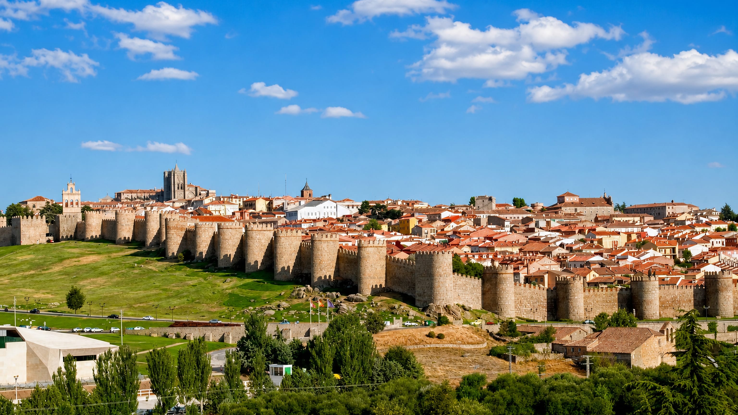 Ávila's medieval stone walls and round turrets encircling the old town, with the cathedral tower rising behind.