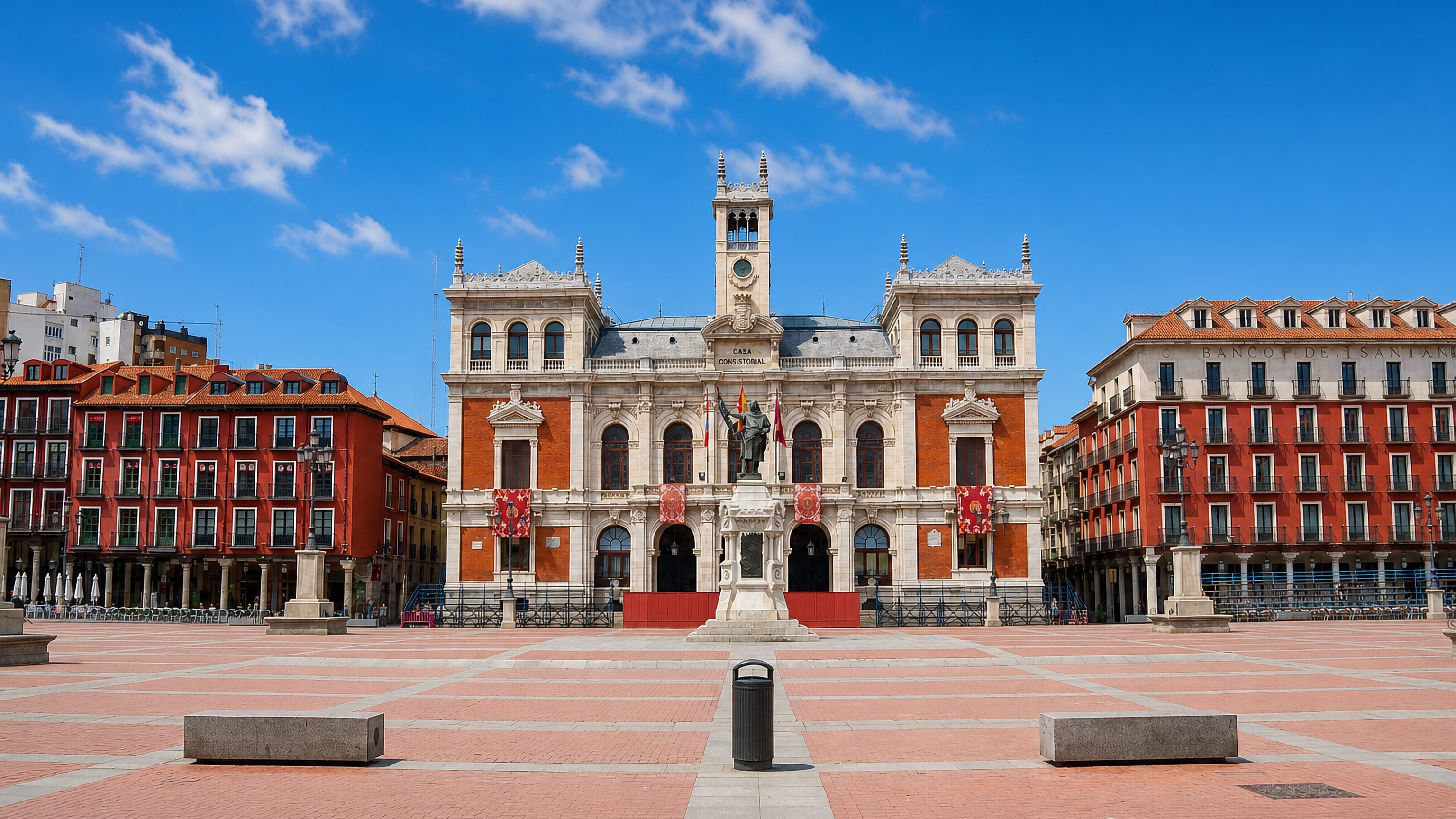 Plaza Mayor in Valladolid, arcaded red facades framing the Casa Consistorial city hall and clock tower.