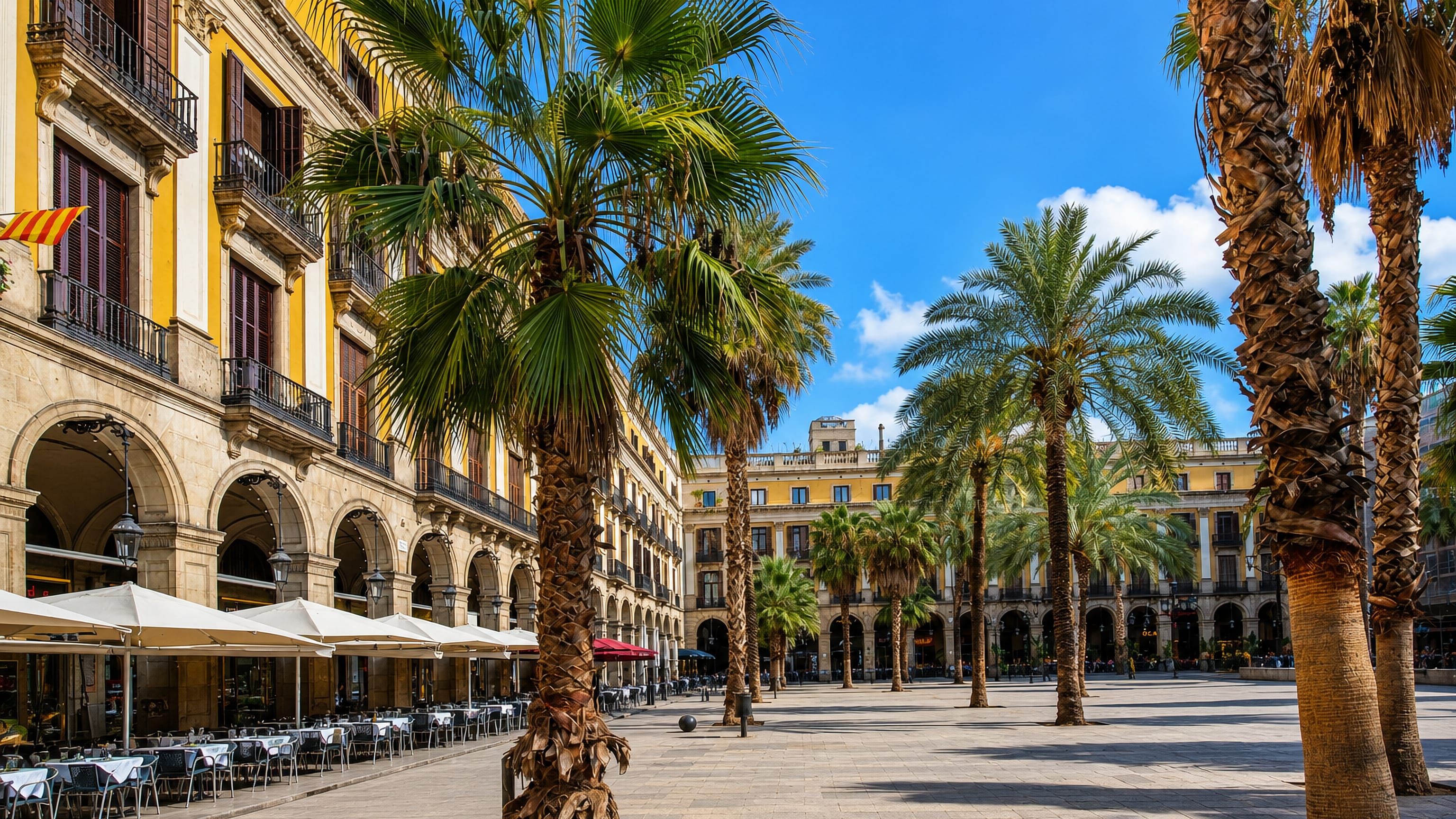 Palm-lined arcaded Plaça Reial with cafe terraces in the Barri Gotic, Barcelona's Gothic Quarter.
