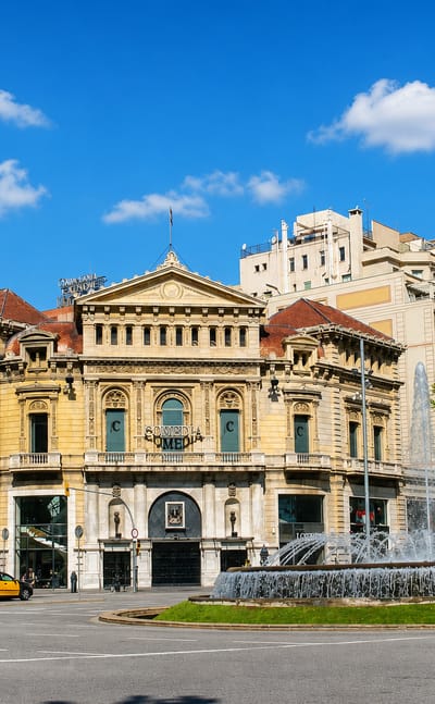 Grand Beaux-Arts theatre building and fountain on a boulevard in the Dreta de l'Eixample, Barcelona.