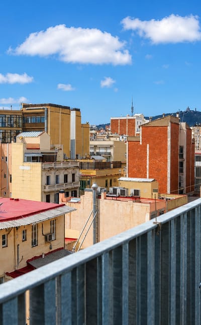 Rooftop view over the dense Gracia district of Barcelona with the Collserola tower and Tibidabo hill behind
