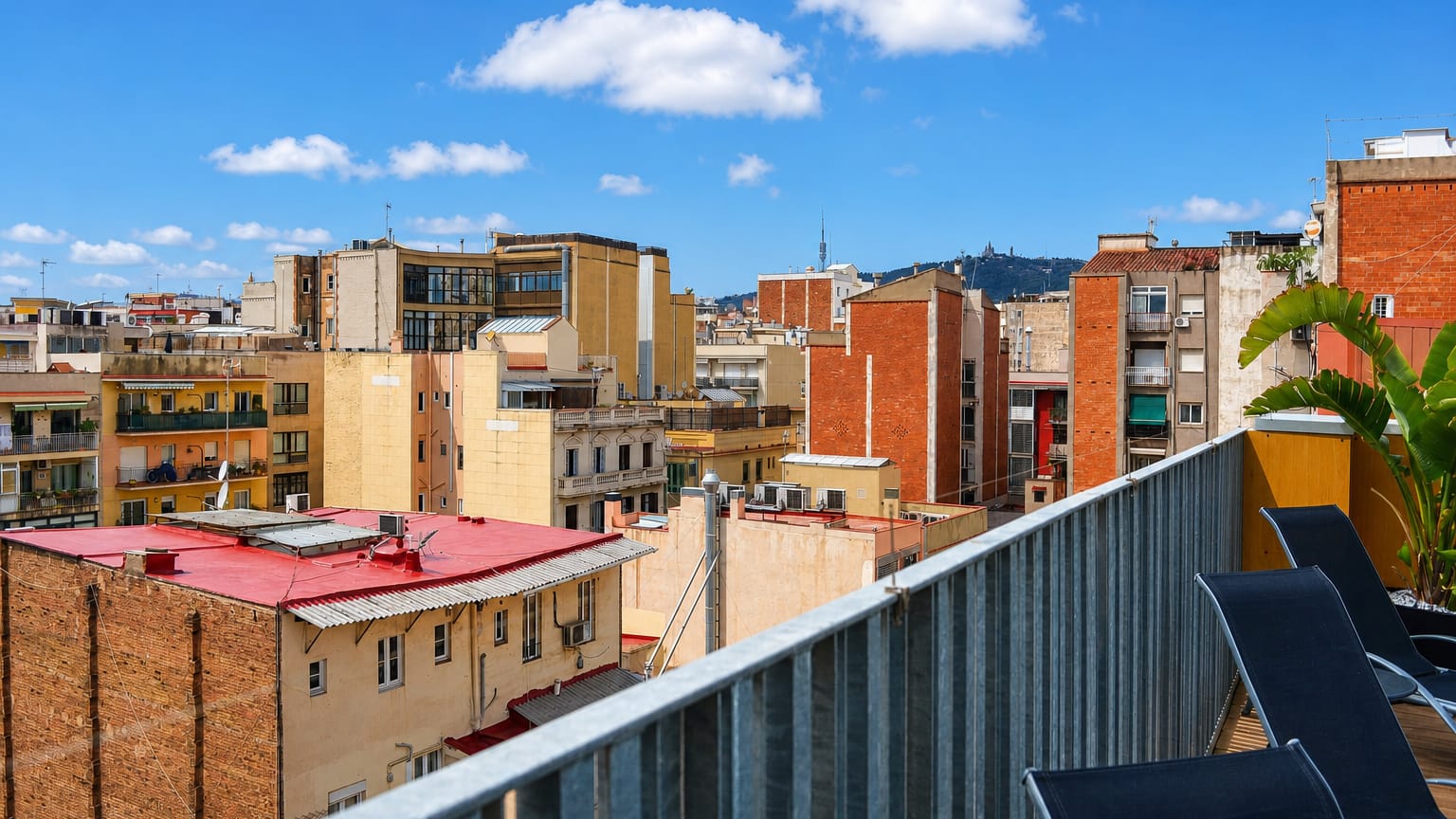 Rooftop view over the dense Gracia district of Barcelona with the Collserola tower and Tibidabo hill behind