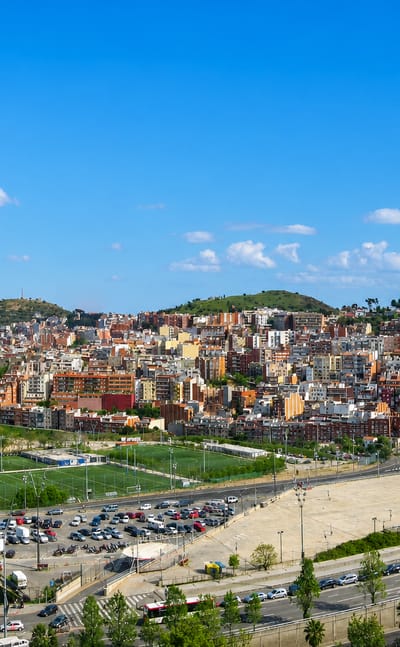 Hillside townscape of dense housing, sports fields and roads climbing the Collserola slopes in Barcelona's Horta-Guinardo district