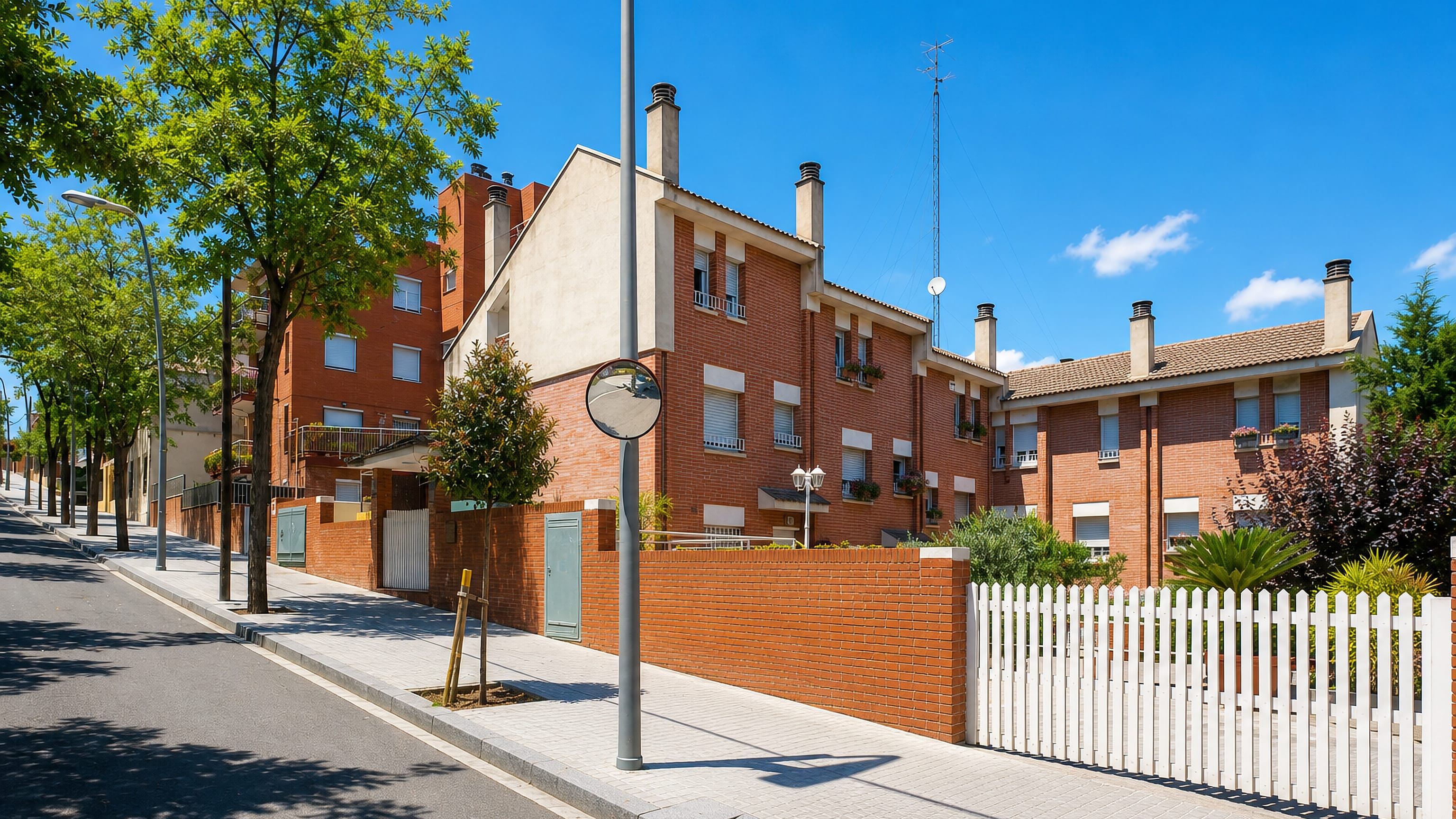 Brick townhouses along a tree-lined residential street in la Font d'en Fargues, Barcelona.