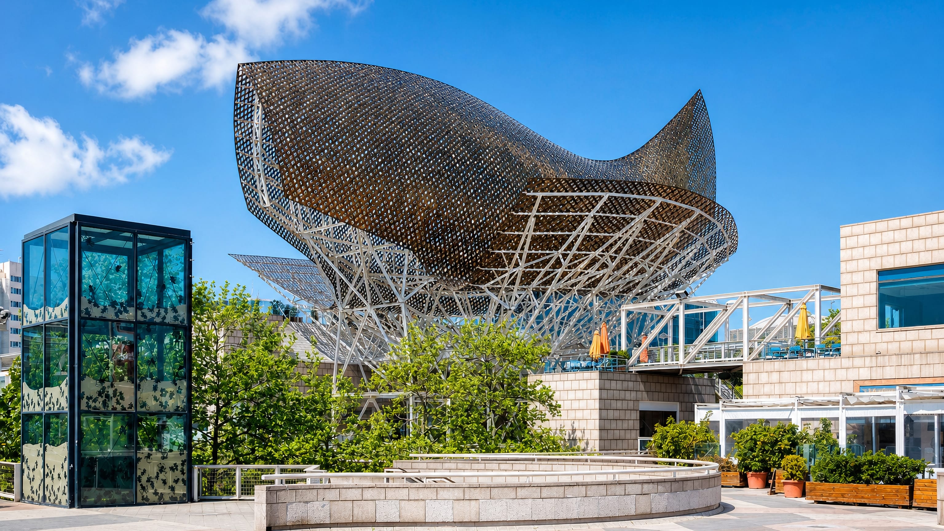 The golden Fish sculpture at Port Olímpic in la Vila Olímpica del Poblenou, Barcelona, under blue sky.