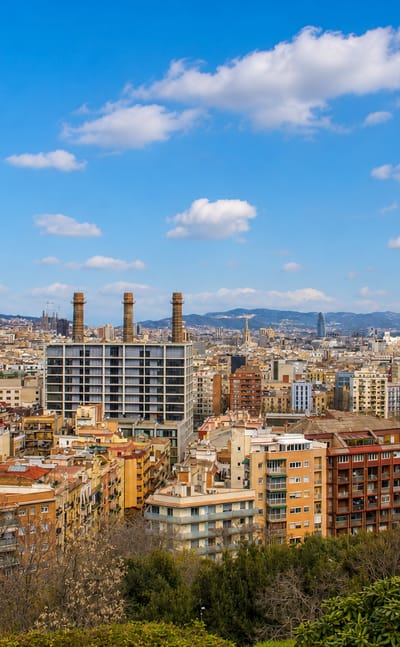 Rooftops of Poble Sec below Montjuic with the three chimneys of the old Paral·lel power station, Barcelona.