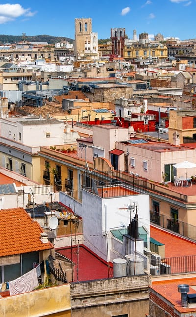 Rooftop view over the dense terracotta roofs and church towers of Sant Pere, Santa Caterina i la Ribera in Barcelona's old town.
