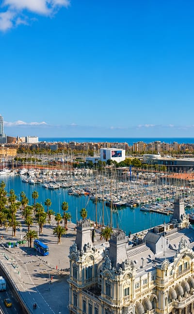 Barcelona's Port Vell waterfront with the ornate Port Authority building, marina, Rambla de Mar bridge and cable-car tower