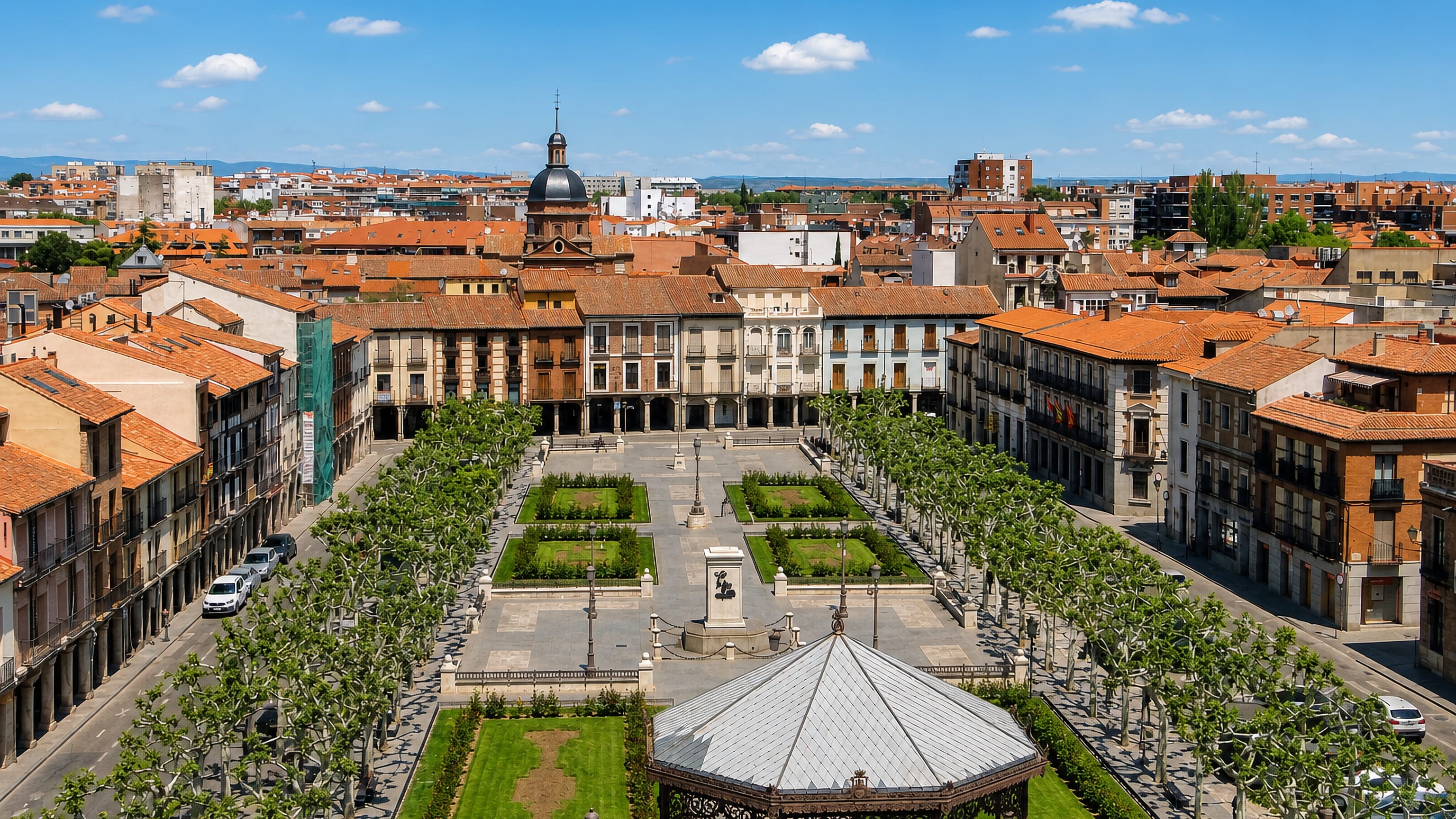Aerial view over Alcalá de Henares' arcaded main square, bandstand and tiled rooftops of the old town.