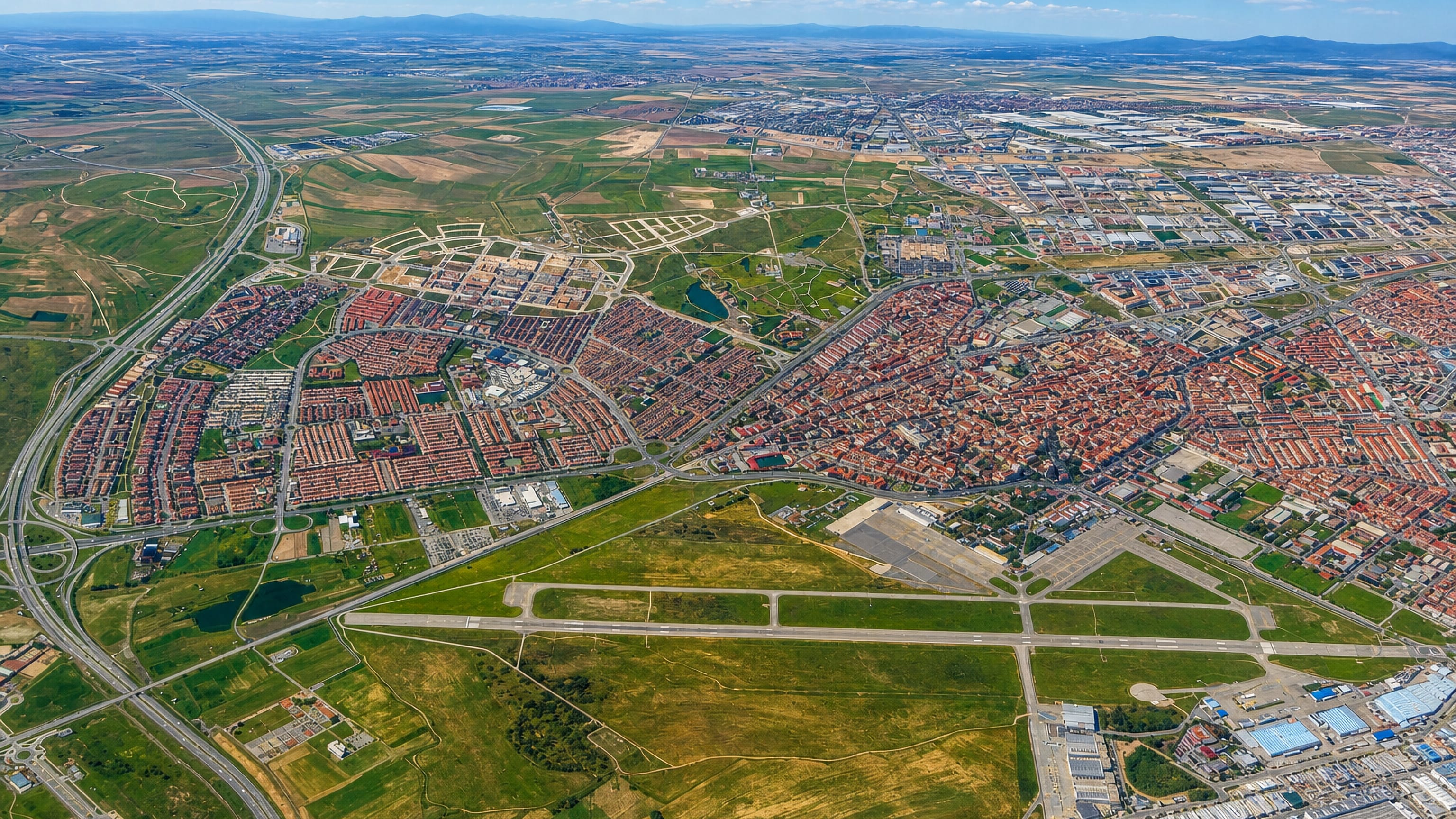 Aerial view of Getafe on the Madrid plain, its dense old town beside the runways of Getafe Air Base.