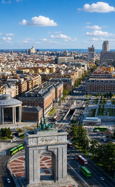 Aerial view of Madrid's Arco de la Victoria and Moncloa district with the city skyline stretching behind, near Aravaca