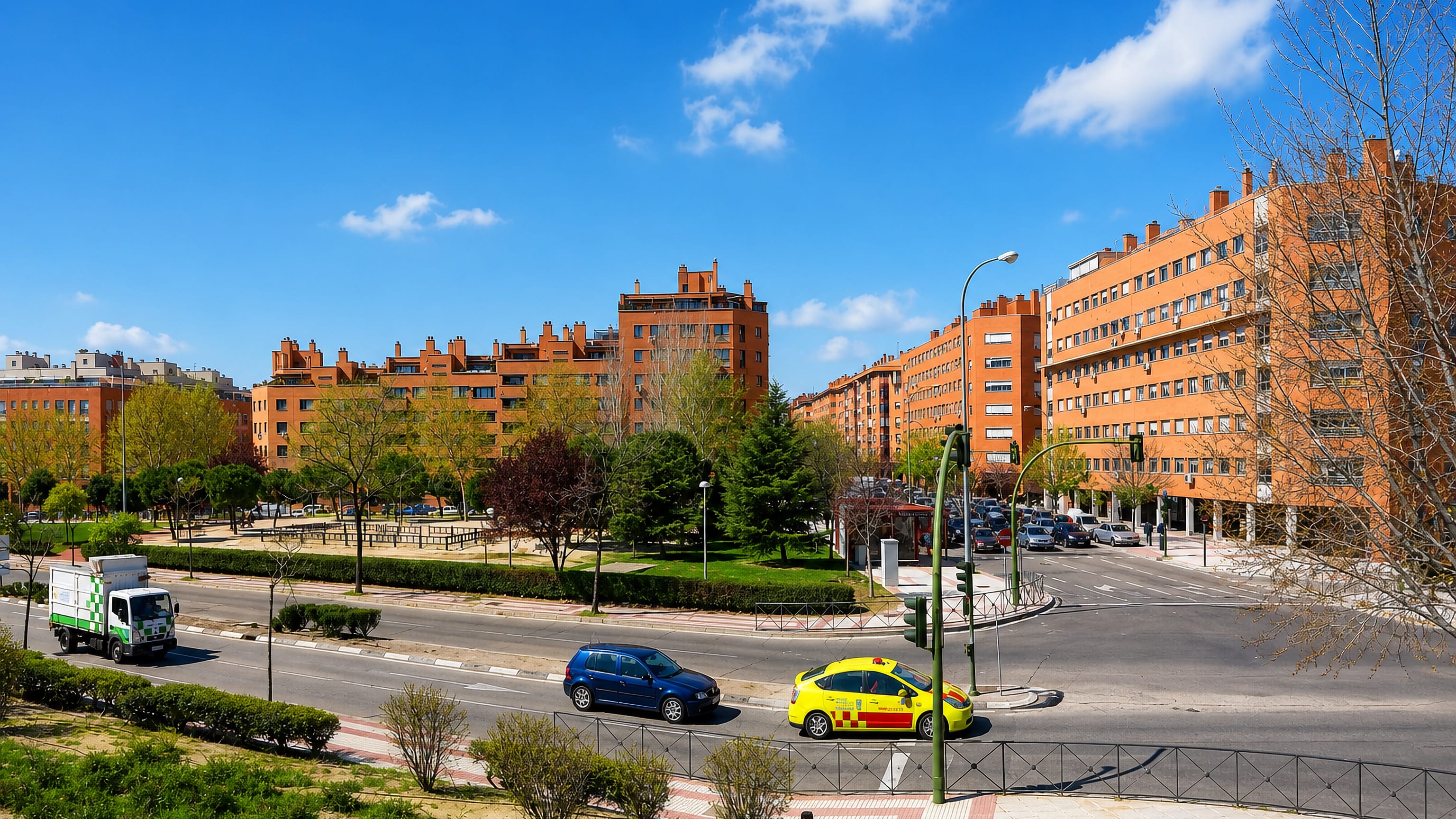 Red-brick apartment blocks and a tree-lined avenue in the Arcos district of Torrejón de Ardoz.