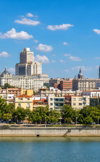 Madrid skyline across the Manzanares river with the Torre de Madrid, Edificio Espana and the domes of the Almudena Cathedral.