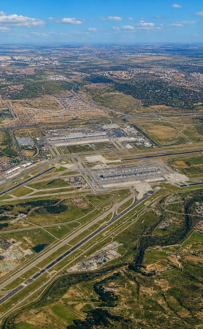 Aerial view over Madrid-Barajas airport runways and the surrounding Barajas district cityscape