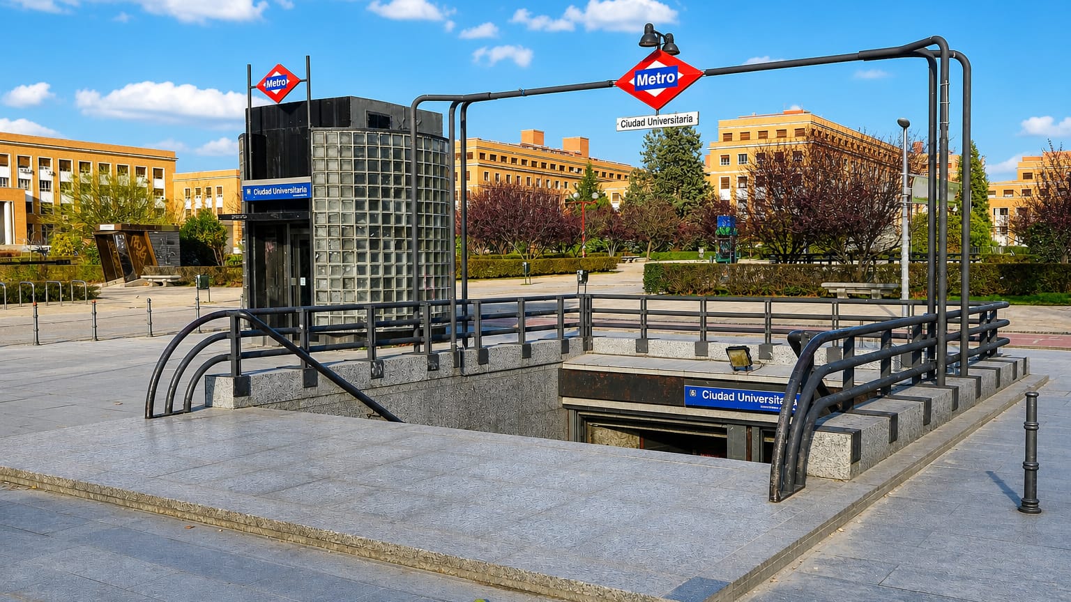 Metro station entrance signed Ciudad Universitaria before university campus buildings in Madrid
