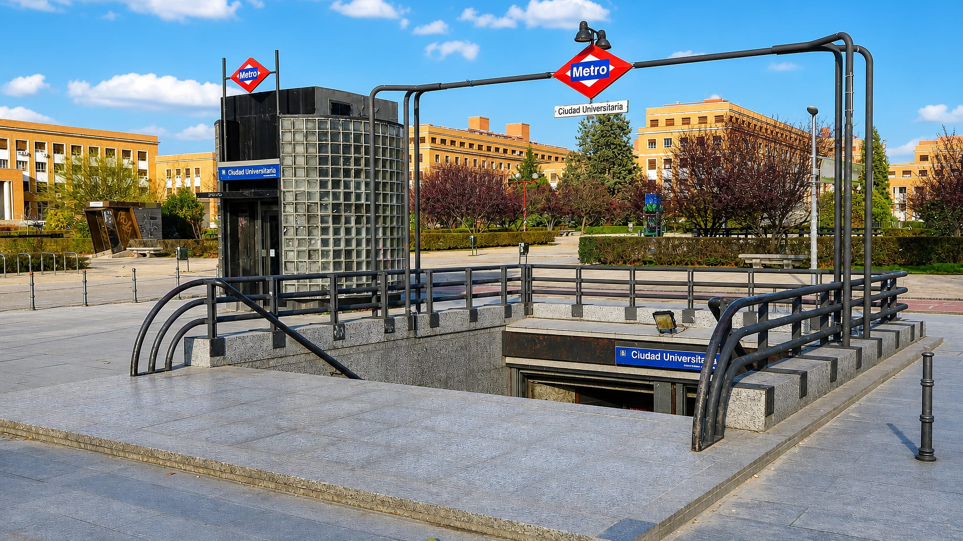 Metro station entrance signed Ciudad Universitaria before university campus buildings in Madrid