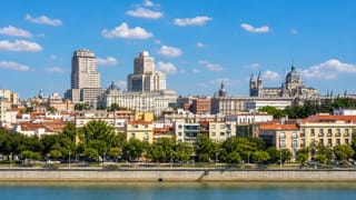 Madrid skyline across the Manzanares river with the Torre de Madrid, Edificio Espana and the domes of the Almudena Cathedral.