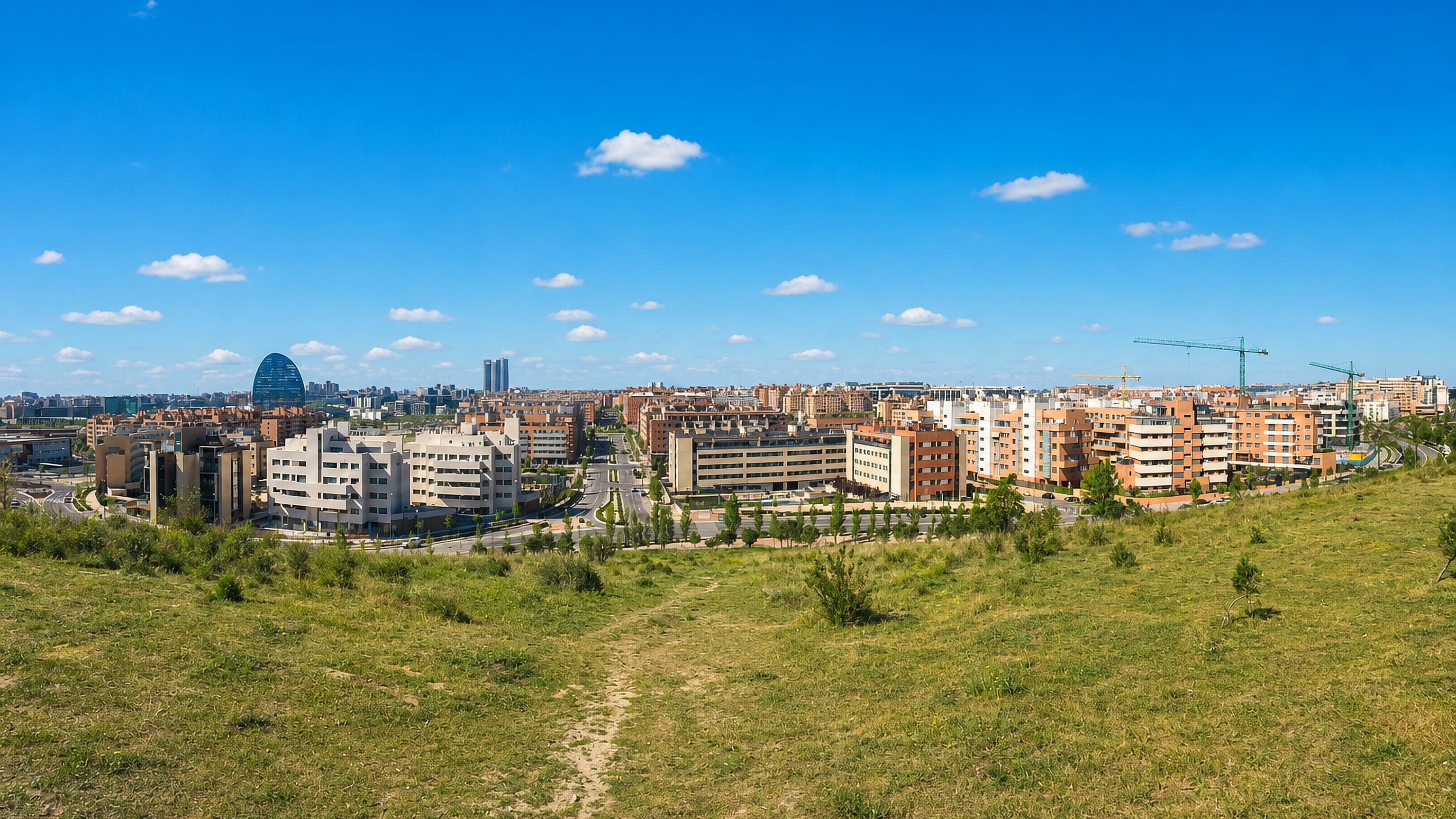 Modern apartment blocks of Las Tablas in northern Madrid with the BBVA tower and Cuatro Torres beyond.