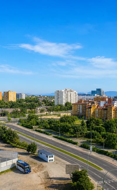 Aerial view of mid-rise apartment blocks and a wide avenue in the Los Rosales district of Madrid