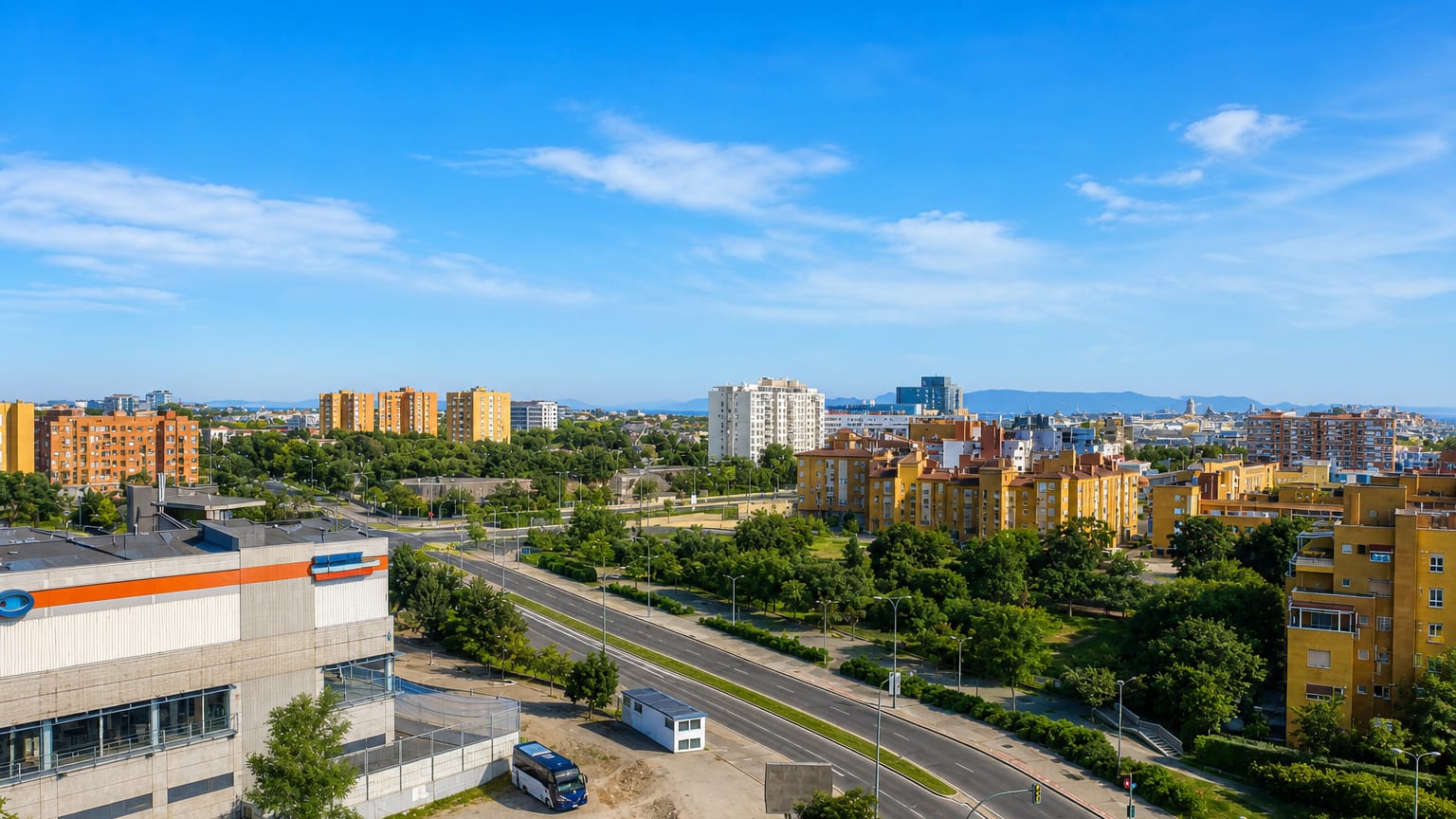 Aerial view of mid-rise apartment blocks and a wide avenue in the Los Rosales district of Madrid