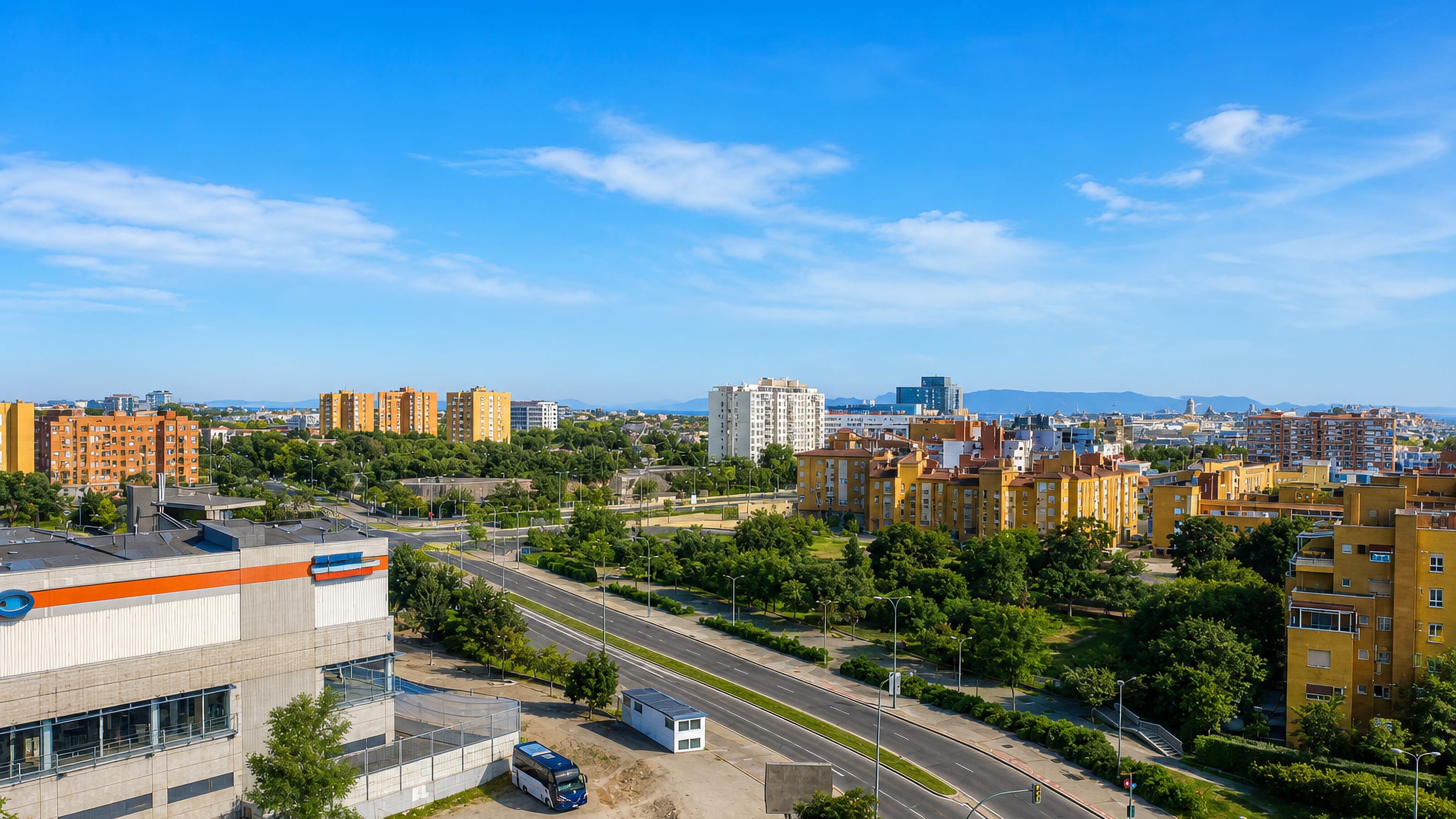 Aerial view of mid-rise apartment blocks and a wide avenue in the Los Rosales district of Madrid