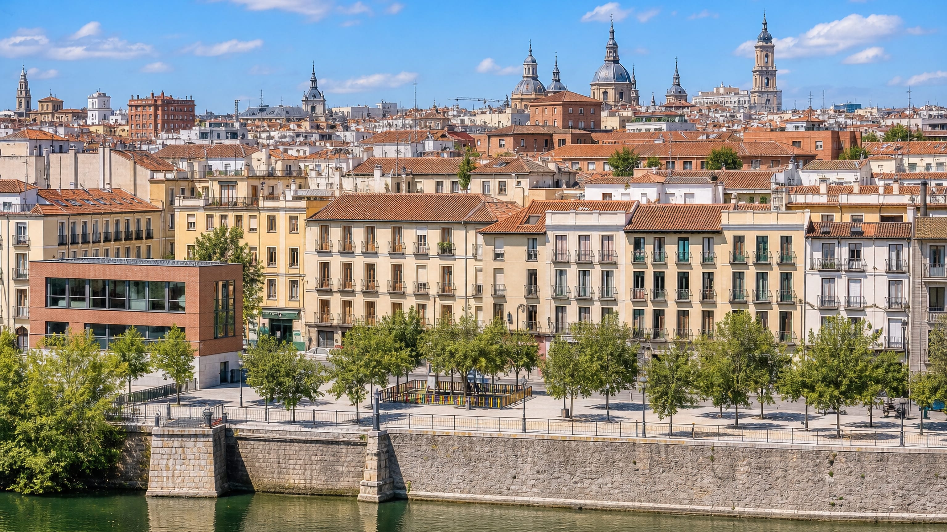 Central Madrid rooftops, church domes and riverside embankment on the approach to the Malasana quarter.