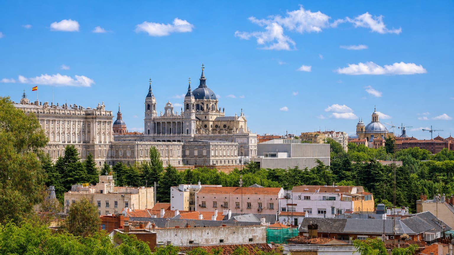 The Royal Palace of Madrid and the domed Almudena Cathedral rising over rooftops in the Palacio neighborhood.