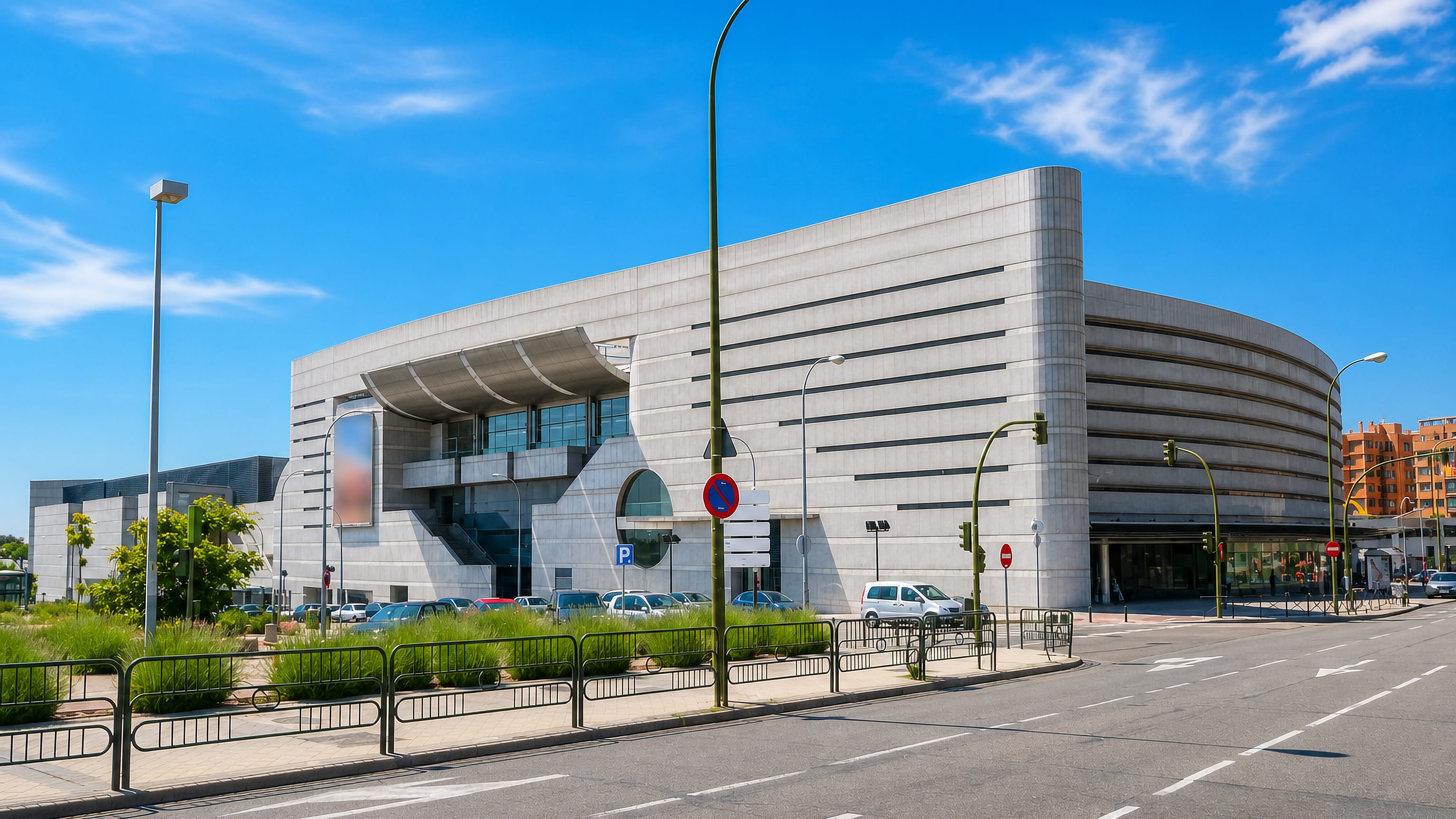 A modern concrete civic building beside a wide avenue in Palomas, Madrid.