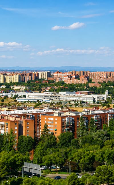 Brick residential towers of Madrid's Palomeras Sureste with the Guadarrama mountains on the horizon