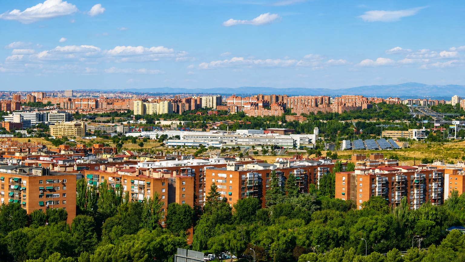 Brick residential towers of Madrid's Palomeras Sureste with the Guadarrama mountains on the horizon