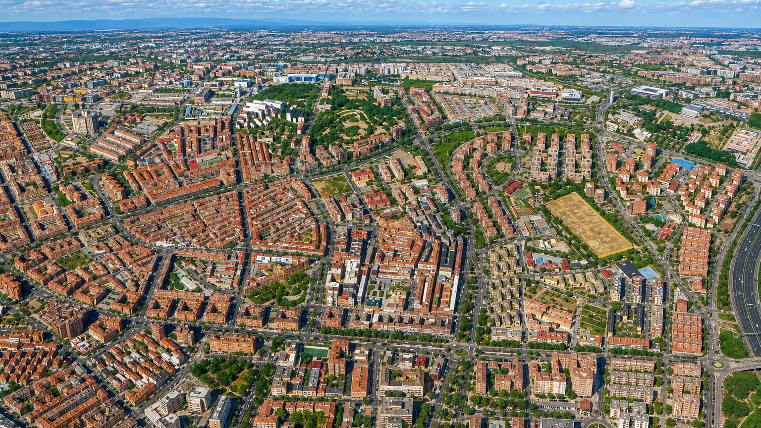 Aerial view over the dense residential grid of Madrid's Portazgo neighbourhood on a clear day