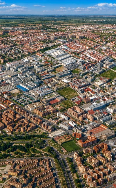 High aerial view over the dense low-rise residential and industrial streets of Simancas in eastern Madrid