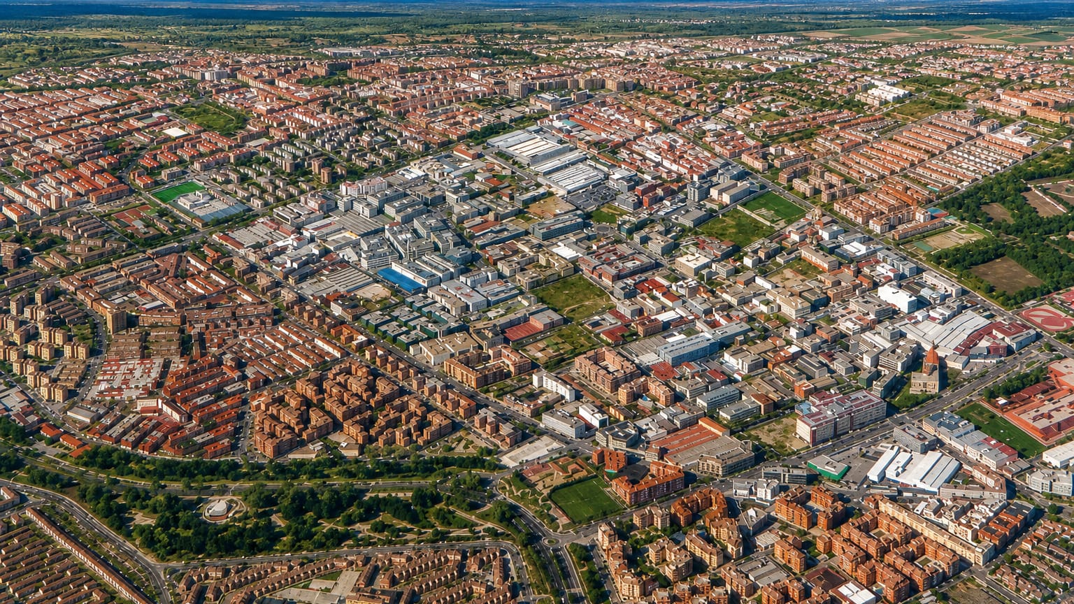 High aerial view over the dense low-rise residential and industrial streets of Simancas in eastern Madrid