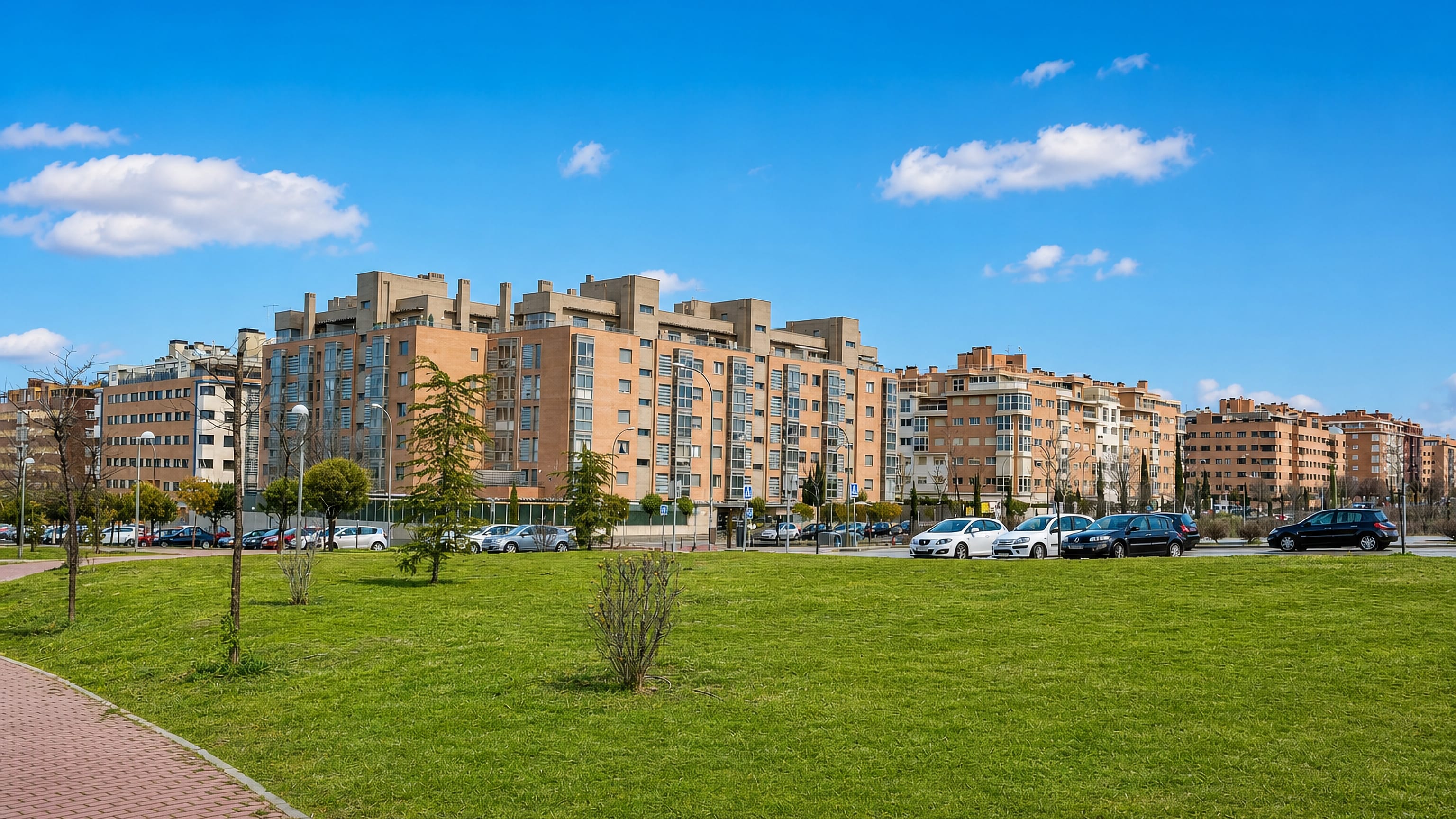 Brick apartment blocks and open lawns in Valdefuentes, a modern residential district of Madrid.